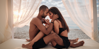 Couple holding each other in romantic cabana on the beach