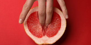 Fingers touching grapefruit